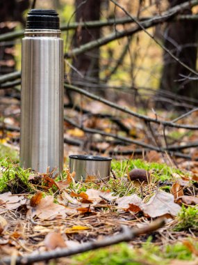 Ahşap zemin üzerinde çay olan termos bardağı.