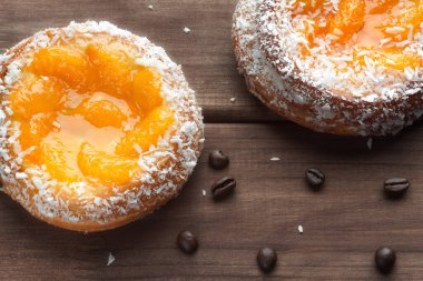 Ahşap bir arka planda hindistan cevizi talaşı ile kayısı çörekleri.