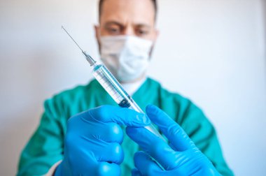 Elinde Covid aşısı olan bir şırıngayla doktor.