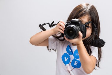Küçük kız kamera / küçük kız elinde kamera arka plan / küçük kız elinde Dslr fotoğraf çekmek için kamera