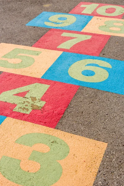 Хопскотч / Hopscotch / Hopscotch на детской площадке с номерами на земле — стоковое фото