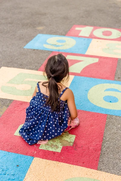 Liten flicka spela hoppa hage / liten flicka spelar hoppa hage på lekplats — Stockfoto