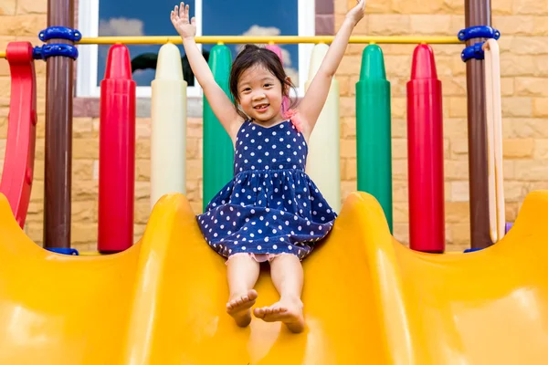Девочка, играющая на детской площадке / Счастливая девочка, играющая на детской площадке — стоковое фото