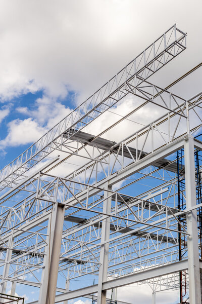 Construction of steel frame of big building with blue sky background.