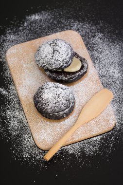 Krema şeker ile çörek / çörek / çörek buzlanma ile siyah arka plan üzerine şeker