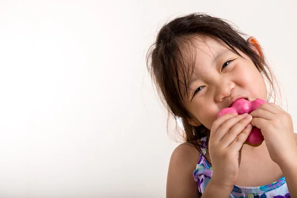 Liten flicka äter donut — Stockfoto