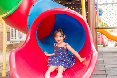 Küçük kız oyun bahçesinde oynuyor.