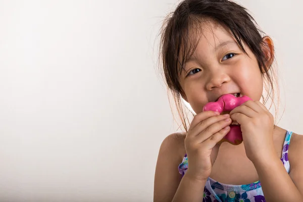 Маленькая девочка ест пончик — стоковое фото