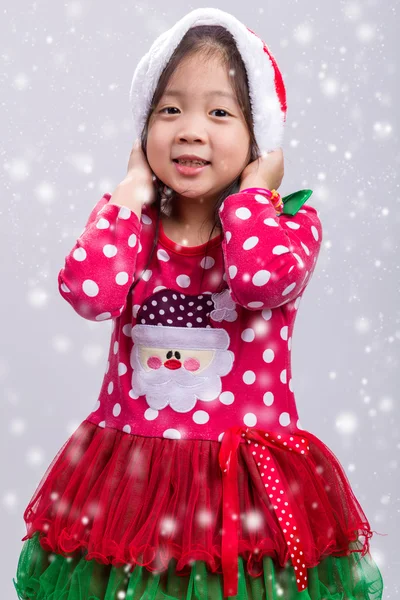 Kind im Weihnachtskostüm mit Weihnachtsmann-Hut mit Schnee — Stockfoto