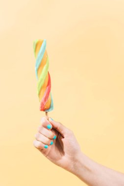 Bilinmeyen kişi çok renkli bir dondurmayı kavramış. dikey resim