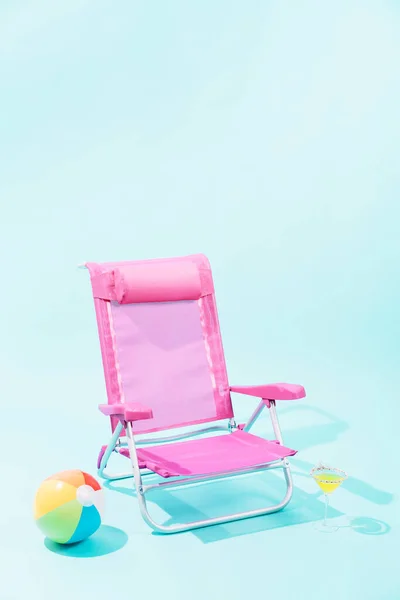 Ein Pinkfarbener Strandkorb Mit Einem Bunten Strandball Auf Blauem Hintergrund — Stockfoto