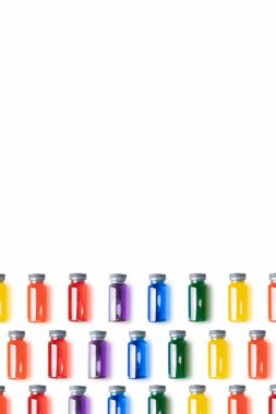 Beyaz zemin üzerinde gökkuşağı renkli sıvı bulunan cam şişelerin deseni. Aşı ve covid kavram. Kopya alanı olan dikey görüntü..