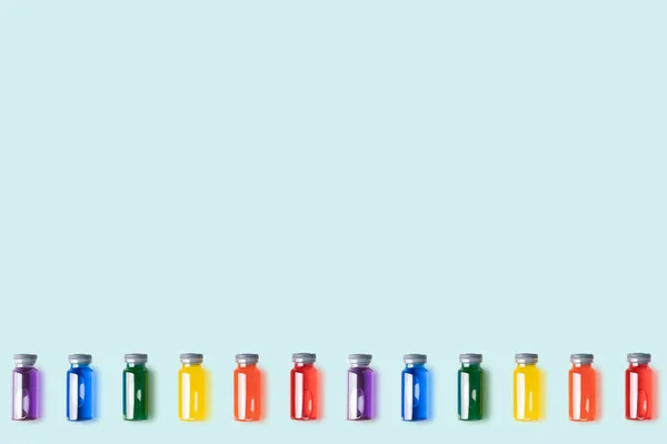 Üvegből Készült Injekciós Üvegek Mintázata Szivárványszínű Folyadékkal Kék Háttér Mellett — Stock Fotó
