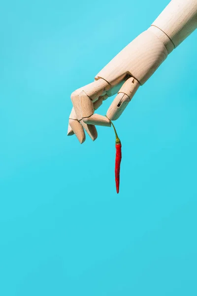 Hölzerne Hand Die Eine Rote Chilischote Auf Blauem Hintergrund Hält — Stockfoto