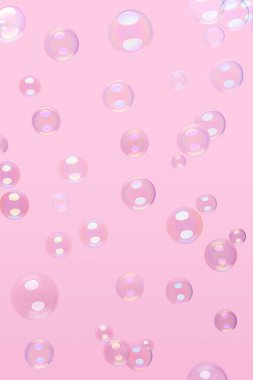 Pembe arka planda çeşitli sabun köpükleri.