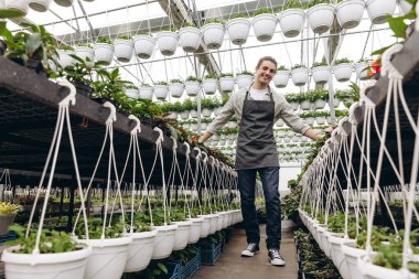 Bahçede çalışırken önlük giyen çekici bahçıvan.