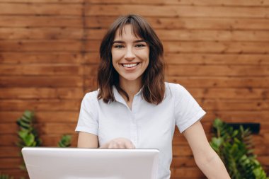Dükkanda çalışan ve kasanın yanında duran bir kadın satıcı.