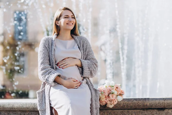 通りを歩く花のきれいな妊婦さん 茶色の目をした美しいブロンドの女の子 プロの化粧品 幸せで気楽な妊娠 秋の通り — ストック写真