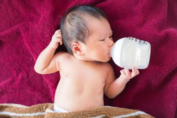 Bebé recién nacido comiendo leche del biberón . — Foto de Stock