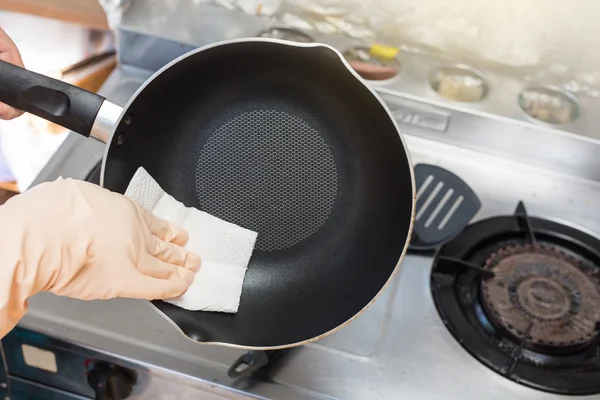 Женские руки используют белую сковороду для чистки ткани . — стоковое фото