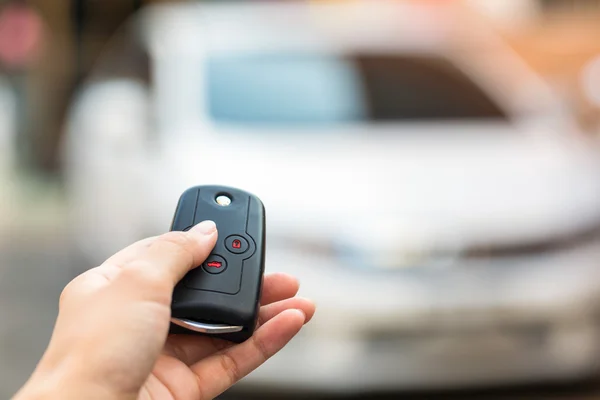 Main féminine ouvrir la voiture blanche sur le système de clé automatique . — Photo