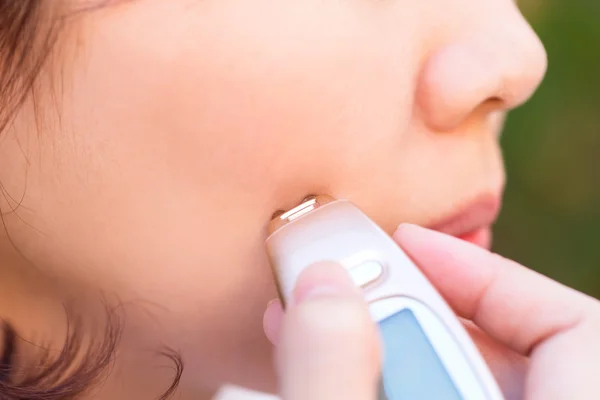 Nahaufnahme einer Person, die das Gesicht der Haut mit dem Dermatoskop überprüft. — Stockfoto