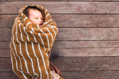 Kürk kumaş ahşap masa üzerinde yatan küçük bebek.