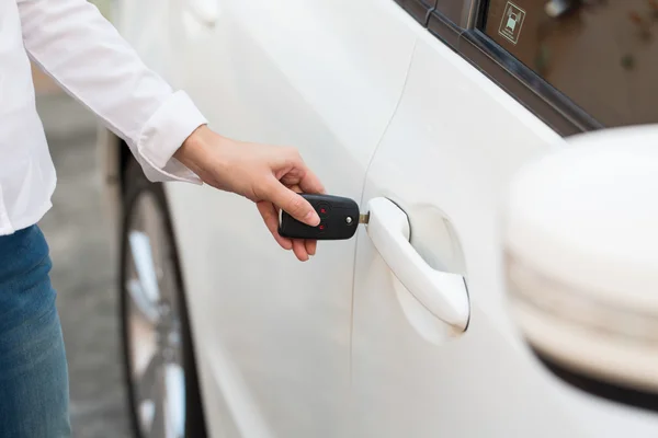 Ženská ruka otevřít bílé auto na klíč systému automatického. — Stock fotografie