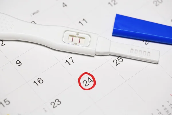 캘린더와 긍정적인 임신 테스트. — 스톡 사진