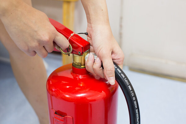 Close- up Fire extinguisher and pulling pin on red tank.