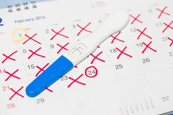 Позитивний тест на вагітність з календарем . — стокове фото
