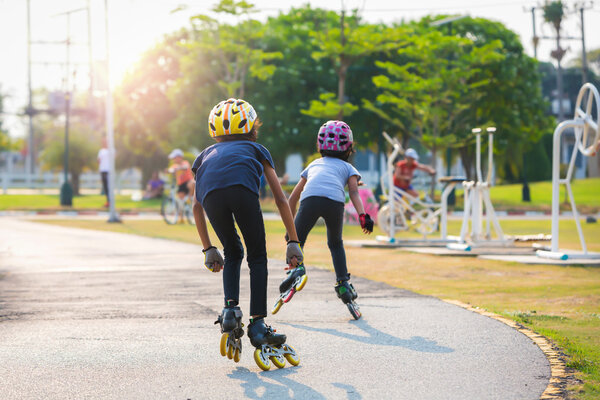 Young couples roller skates outdoor in park.