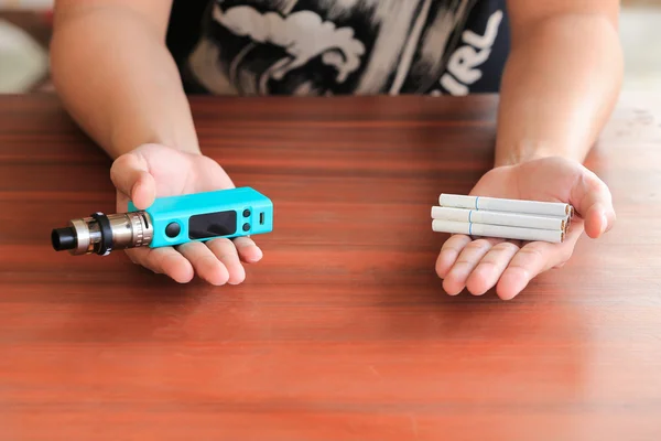 Hands holding between the classic cigarette or electronic cigare — Stock Photo, Image