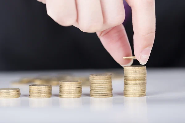 Close-up van mannenhand vulling geld stapel op gouden munten balk. — Stockfoto