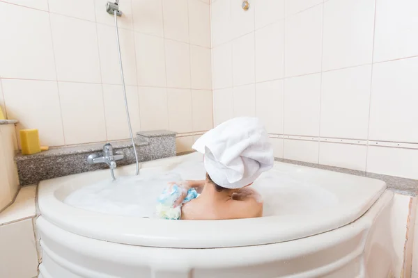 Jovem menina bonita tomando banho na banheira . — Fotografia de Stock