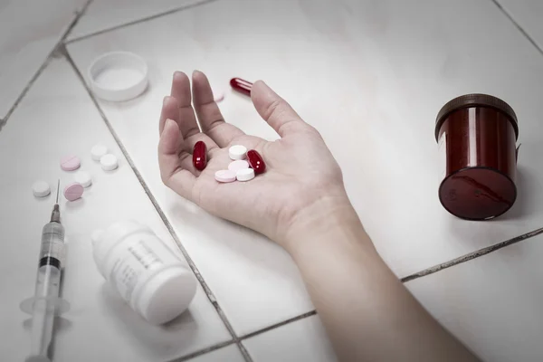 Centrarse en las mujeres de la mano después de comer pastillas sobredosis . — Foto de Stock