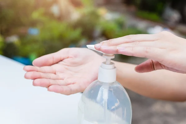 Kvindelige hænder ved hjælp af vask hånd sanitizer gel pumpe dispenser. - Stock-foto