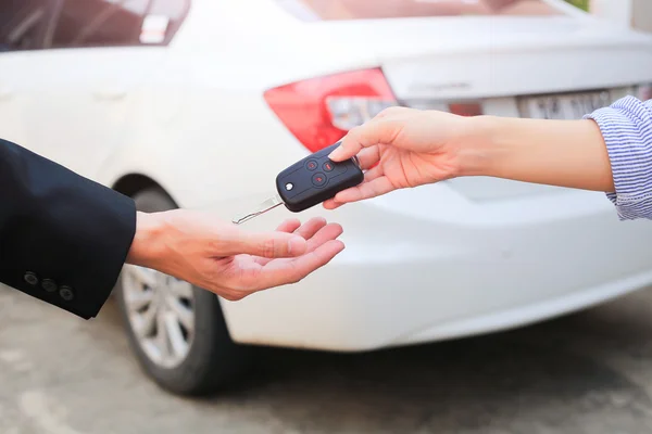 Mão de negócios dando uma chave para comprador ou carro alugado . — Fotografia de Stock