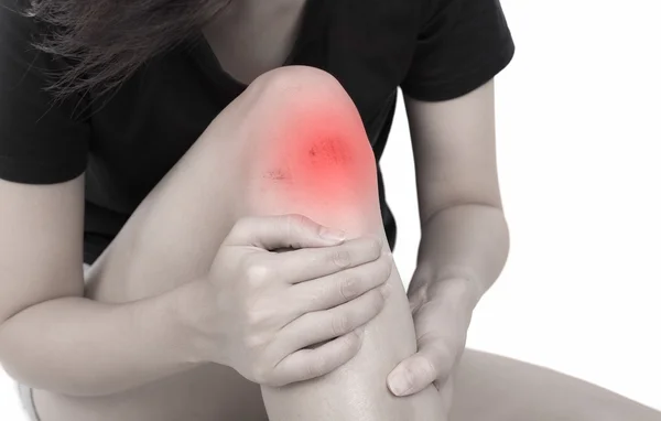 Женщина с коленом чувствует боль на белом фоне — стоковое фото