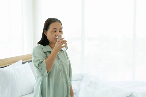 Seniorin Trinkt Morgens Wasser Bett — Stockfoto