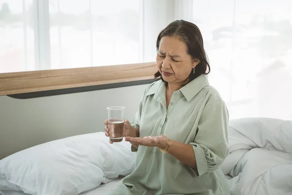 Депрессивная Пожилая Женщина Страдает Суицидальной Депрессии Некоторыми Таблетками Стаканом Воды — стоковое фото
