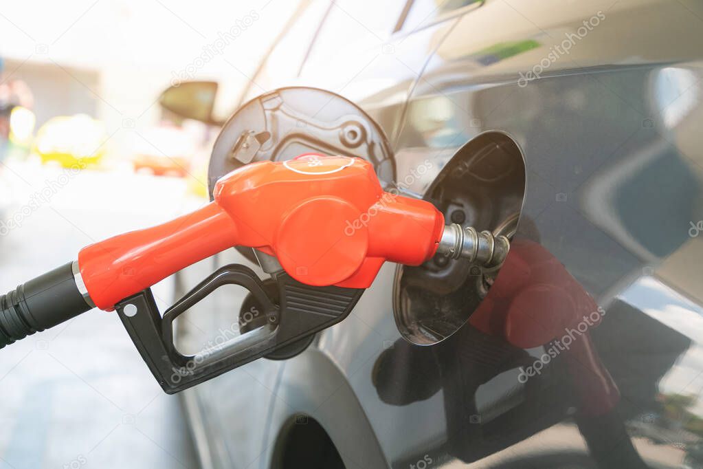 Man pumping gasoline fuel in car at gas station. Transportation and ownership concept.