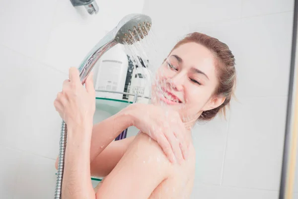 亚洲女人正在洗澡 享受着泼洒在身上的水 — 图库照片