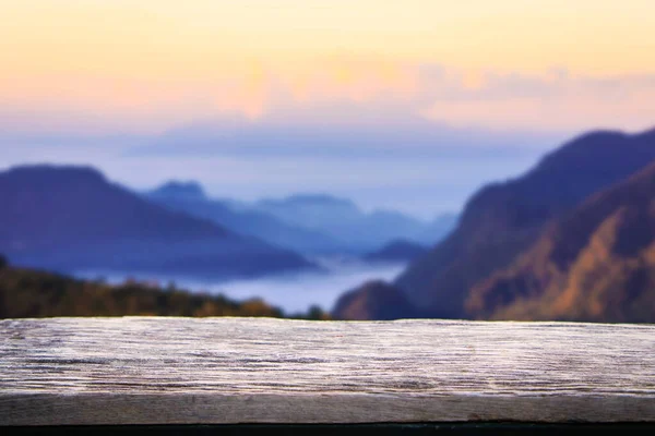 Empty wooden table or wooden terrace with beautiful view of mountain in the early morning.
