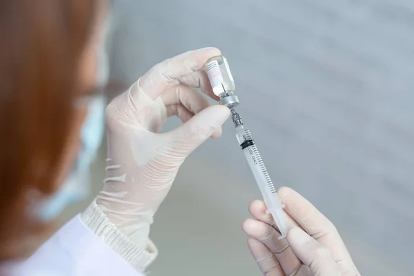 Asian medical worker, nurse in mask, hold syringe with vaccine. Covid-19, coronavirus disease, healthcare workers concept.