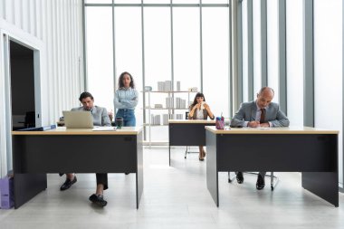 Bir grup genç iş adamı ofiste birlikte çalışıyor ve iletişim kuruyor..