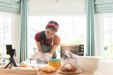 Kadın, restoranın mutfağında fırıncının ellerini unla çırpıyor..