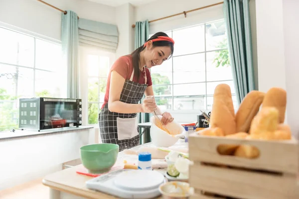 ハッピー女性は 現代的なキッチンで手でペストリークッキーのための生地をこねる新鮮な天然製品小麦粉ミルク卵を使用しています — ストック写真