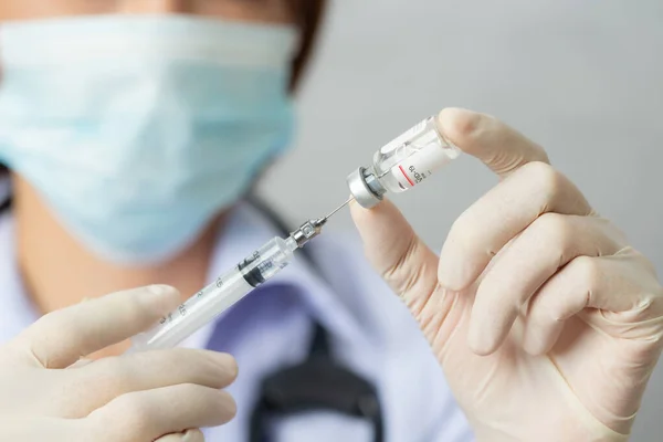 Asyalı sağlık görevlisi, maskeli hemşire, aşılı şırınga. Covid-19, Coronavirus hastalığı, sağlık çalışanları konsepti.