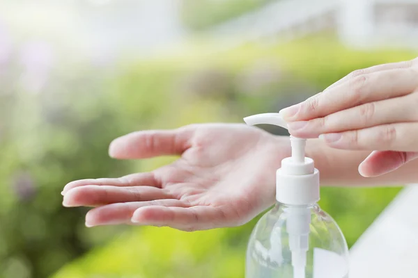 Tangan perempuan menggunakan pembersih tangan untuk mencuci alat pompa gel. — Stok Foto